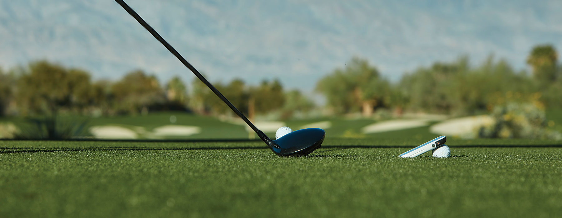Launch Monitors and Simulators - A golf club teeing off in a tee box